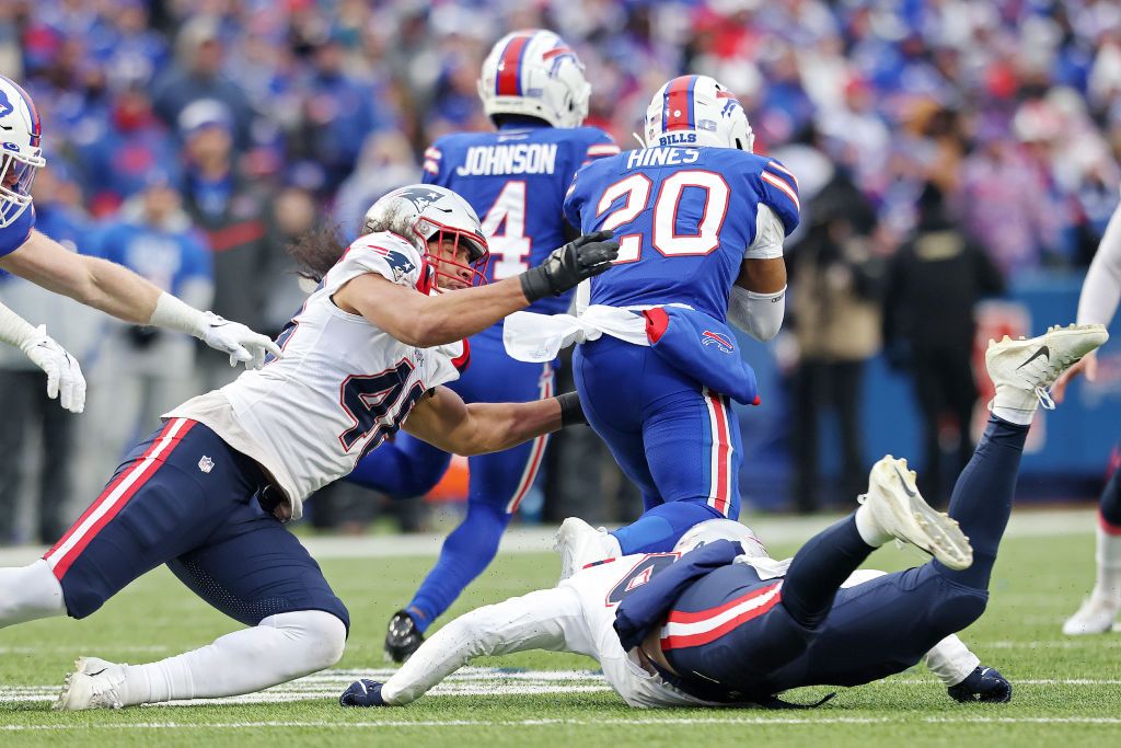 Jahlani Tavai #48 of the New England Patriots and Calvin Munson #43 of the New England Patriots attempt to tackle Nyheim Hines #20 of the Buffalo Bills was Hines returns a kickoff for a touchdown during the third quarter at Highmark Stadium on January 08, 2023 in Orchard Park, New York.