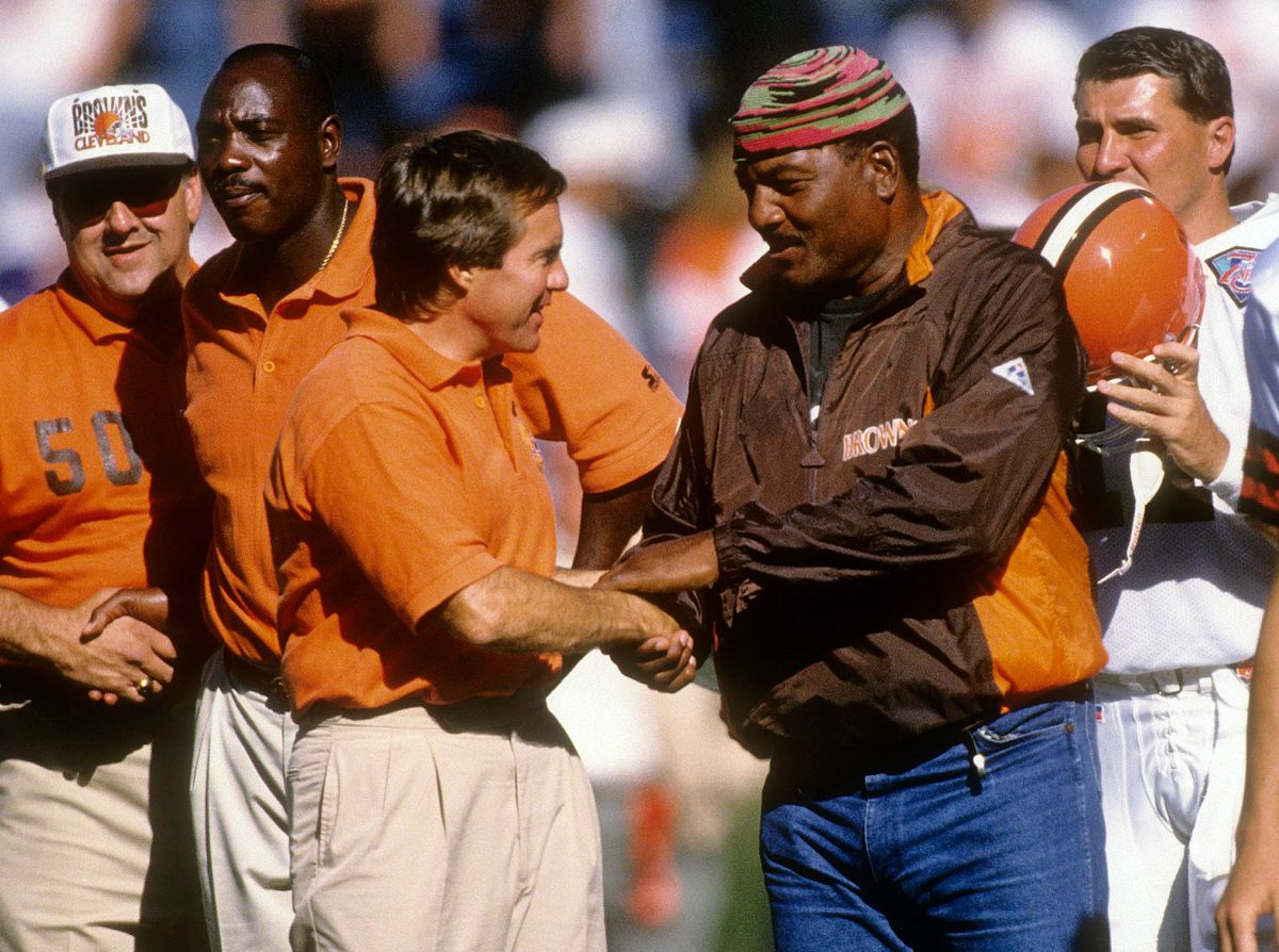 Head coach Bill Belichick (L) of the Cleveland Browns tallks with Cleveland Browns running back great Jim Brown (R) on the sidelines circa 1994 before an NFL football game. Belichick was the head coach of the Browns from 1991-95.